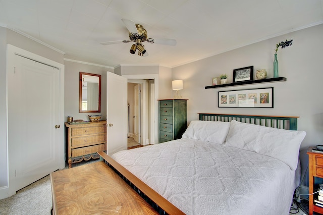 bedroom with ceiling fan, ornamental molding, and carpet