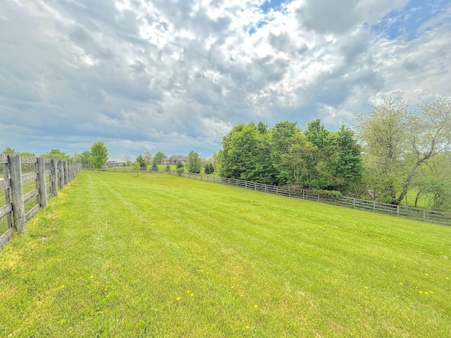 view of yard featuring fence and a rural view