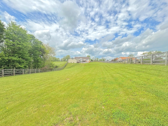 view of yard featuring fence and a rural view