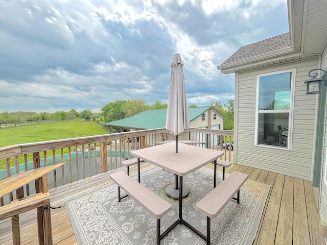 deck featuring a yard, outdoor dining area, and a pool