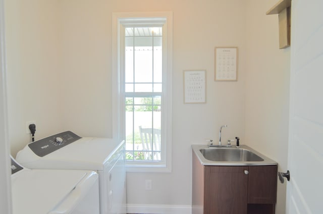 laundry room featuring a sink, baseboards, laundry area, and washing machine and dryer