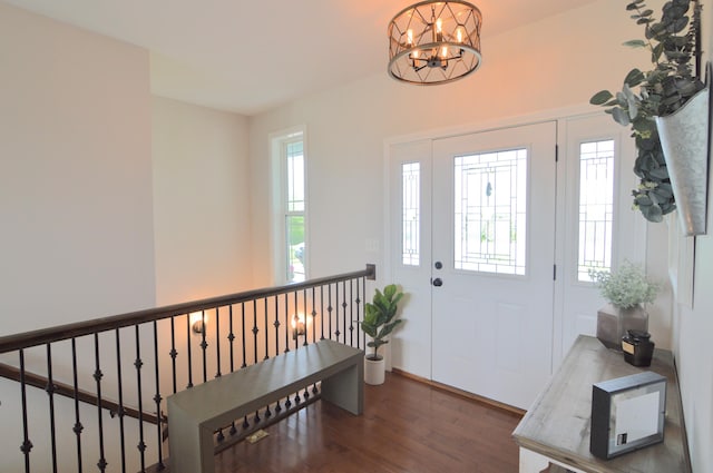 foyer entrance with wood finished floors and a chandelier