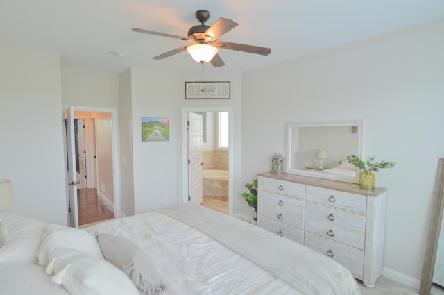 bedroom with baseboards, ceiling fan, and ensuite bath
