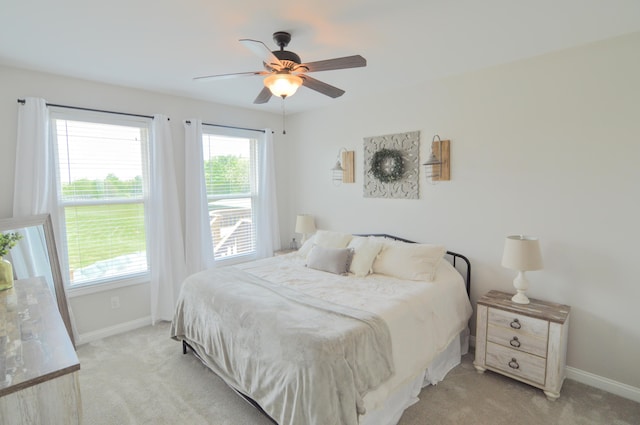 bedroom with baseboards, ceiling fan, and light colored carpet