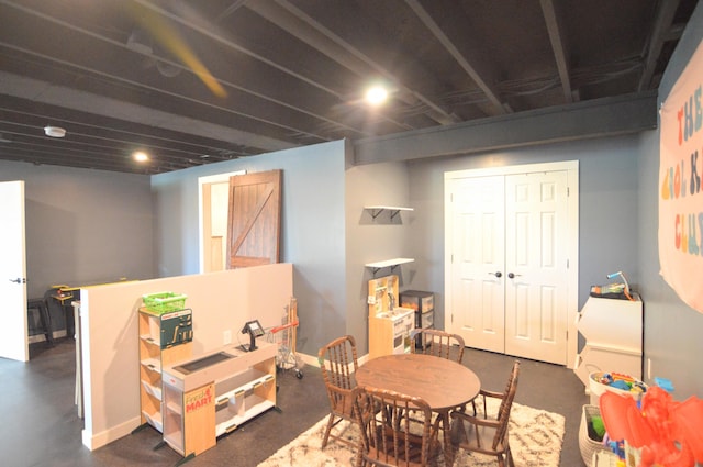 playroom featuring finished concrete flooring and baseboards