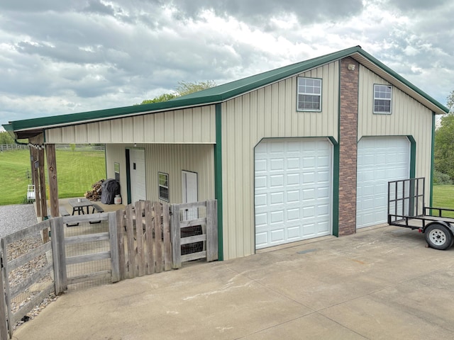garage featuring fence, a gate, and a garage