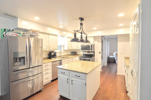1376 Symbo Ln, Walton, KY 41094 - kitchen featuring appliances with stainless steel finishes, white cabinets, a center island, and visible vents
