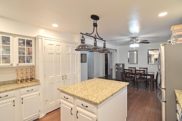 1376 Symbo Ln, Walton, KY 41094 - kitchen with white cabinets, dark wood-style flooring, ceiling fan, a center island, and freestanding refrigerator