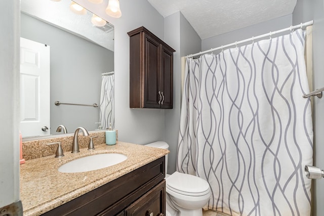bathroom with vanity, a textured ceiling, visible vents, and toilet