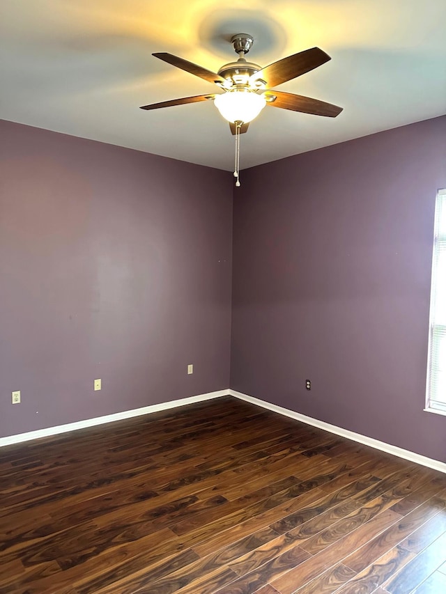 spare room featuring dark wood-style flooring, baseboards, and ceiling fan