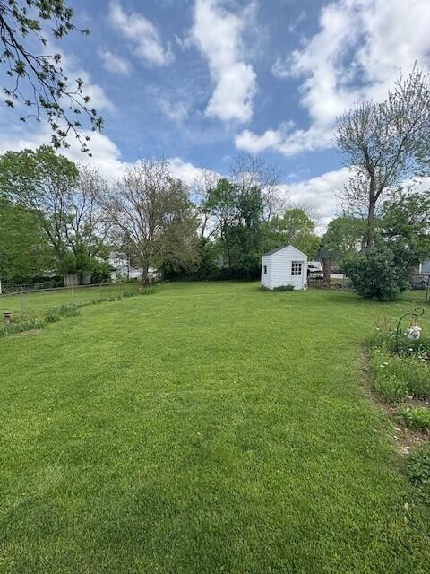 view of yard featuring an outdoor structure and a shed