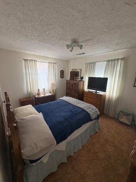 carpeted bedroom with a textured ceiling