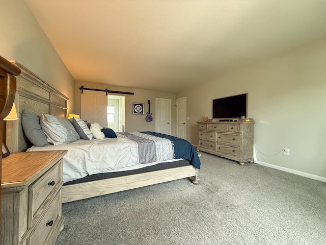 carpeted bedroom with baseboards and a barn door