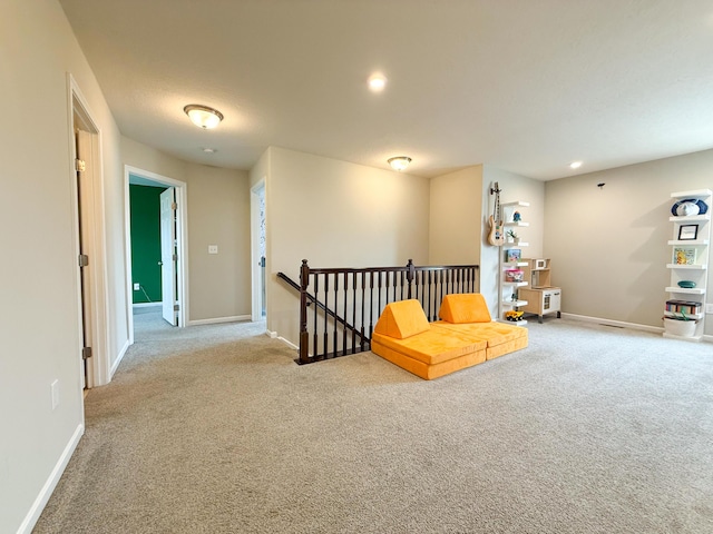 sitting room with an upstairs landing, carpet floors, and baseboards