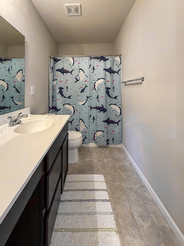 bathroom featuring vanity, baseboards, toilet, a textured ceiling, and a shower with curtain