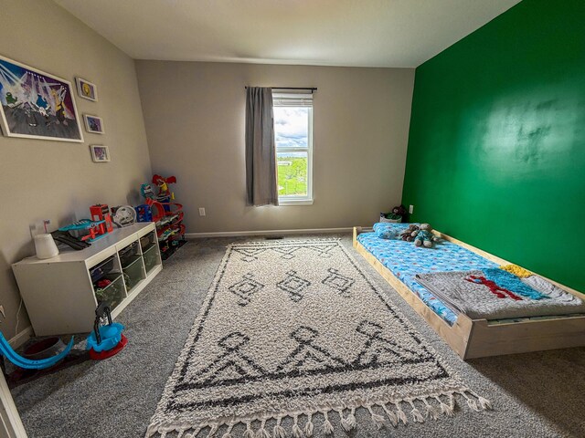 bedroom featuring carpet and baseboards