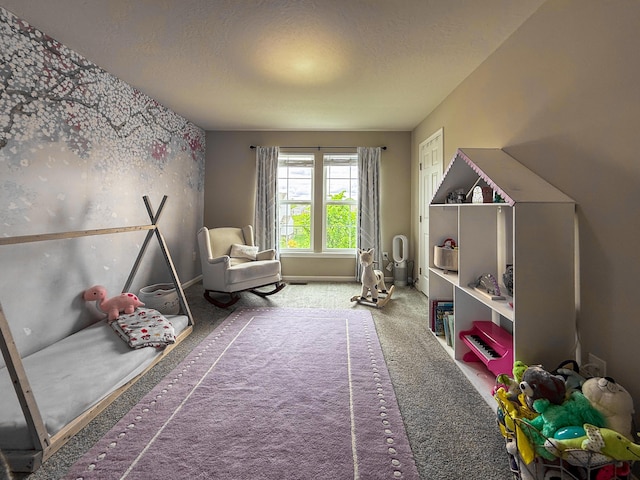 rec room featuring carpet floors, a textured ceiling, and baseboards