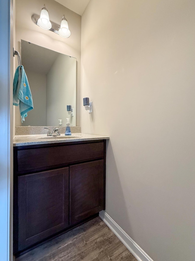 bathroom featuring wood finished floors, baseboards, and vanity