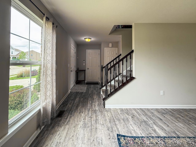 entryway with baseboards and dark wood-style floors