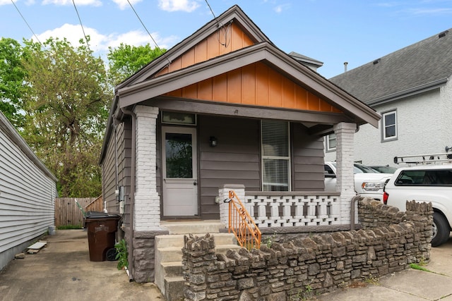 view of front of home featuring covered porch, fence, and board and batten siding