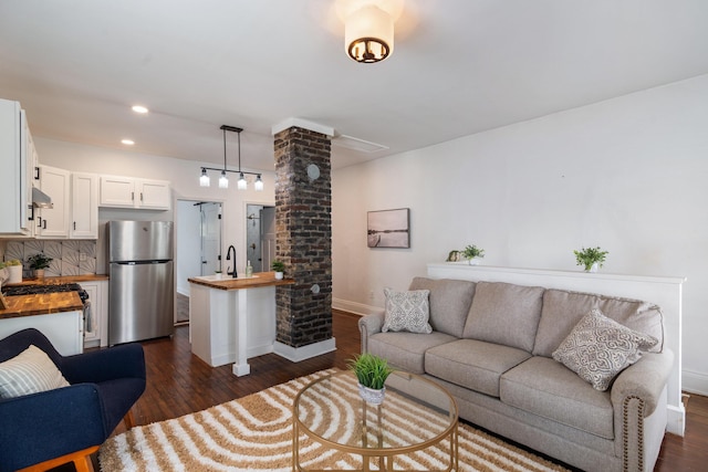 living area featuring baseboards, recessed lighting, and dark wood-type flooring