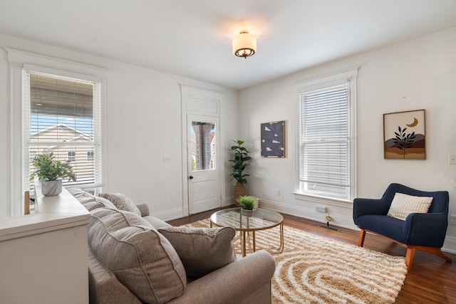 living room featuring baseboards, visible vents, and wood finished floors
