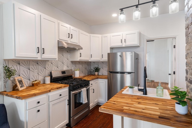 kitchen featuring under cabinet range hood, white cabinets, appliances with stainless steel finishes, and butcher block counters