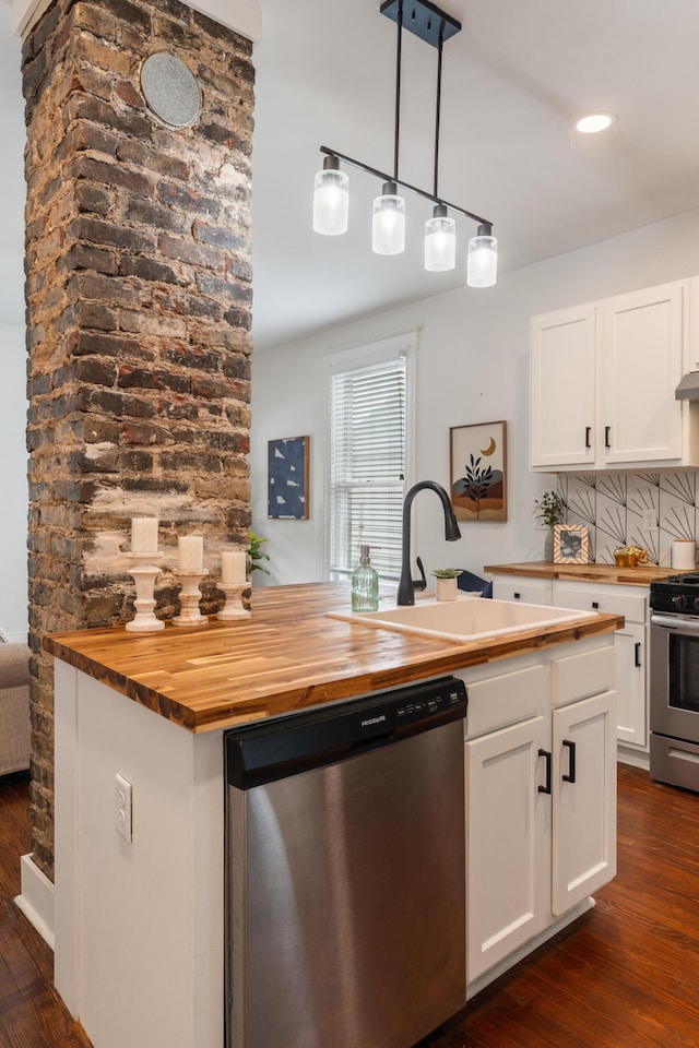 kitchen featuring stainless steel appliances, a sink, dark wood-style floors, and butcher block counters