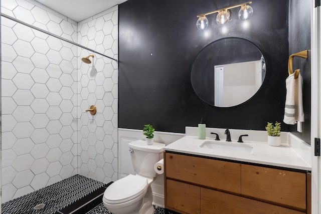 bathroom with vanity, a tile shower, and toilet