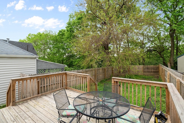 deck with outdoor dining area and a fenced backyard
