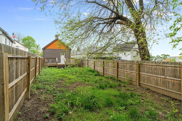 view of yard with a fenced backyard and a wooden deck