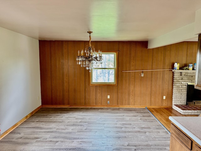 3390 Rector Rd, Morning View, KY 41063 - unfurnished dining area featuring baseboards, wood walls, wood finished floors, and a notable chandelier