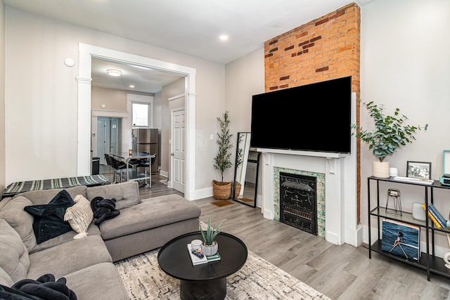 living area with recessed lighting, baseboards, wood finished floors, and a fireplace
