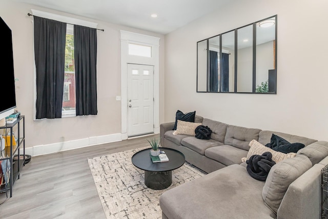 living area featuring recessed lighting, baseboards, a wealth of natural light, and wood finished floors