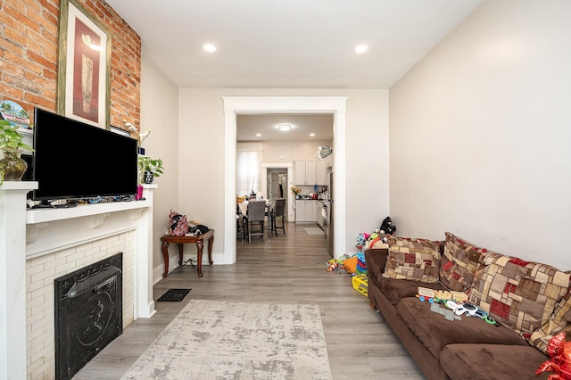 living room featuring recessed lighting, wood finished floors, and a fireplace