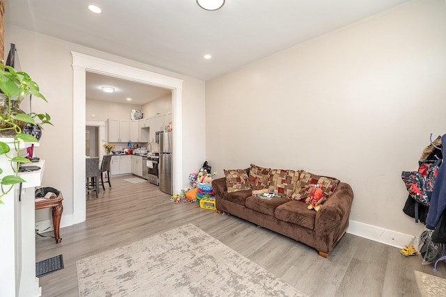 living room with recessed lighting, baseboards, visible vents, and light wood finished floors