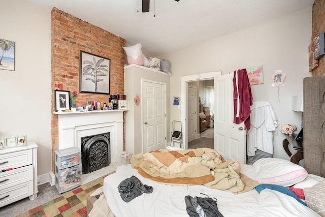 bedroom with carpet flooring, ceiling fan, and a fireplace