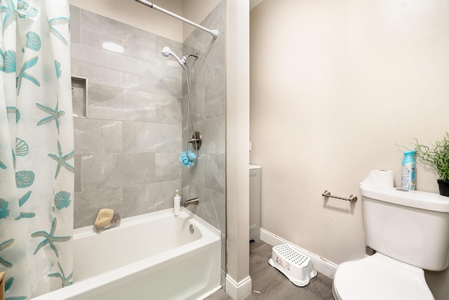 full bathroom featuring baseboards, wood finished floors, shower / bath combination with curtain, and toilet