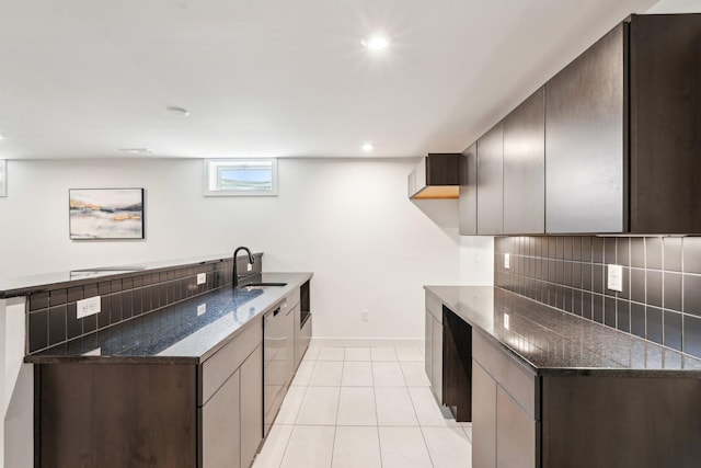 kitchen with a peninsula, backsplash, dark stone countertops, dishwasher, and light tile patterned floors