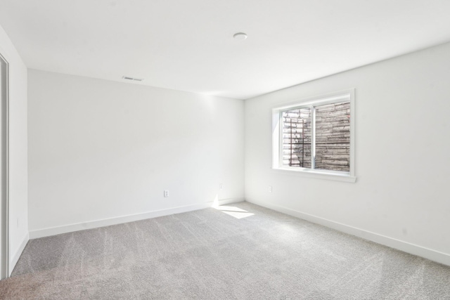 carpeted empty room featuring baseboards