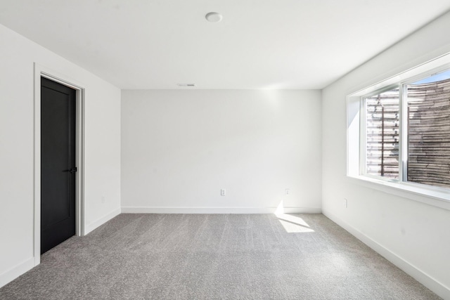 unfurnished room featuring carpet flooring and baseboards