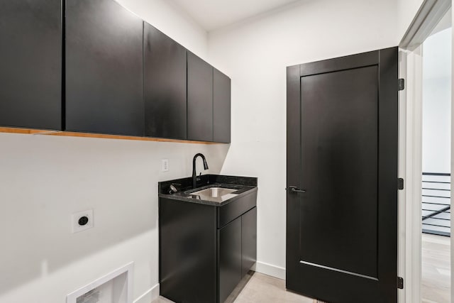 washroom featuring electric dryer hookup, cabinet space, and baseboards