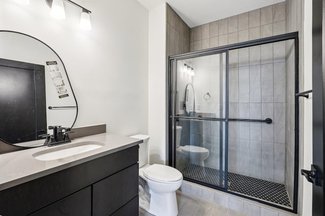 bathroom with toilet, a shower stall, vanity, and tile patterned flooring