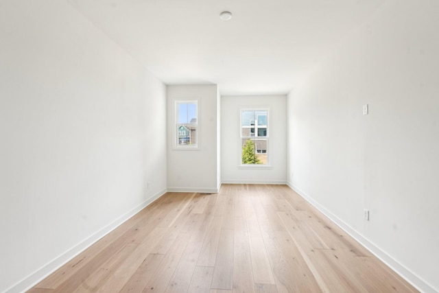 spare room with light wood finished floors and baseboards
