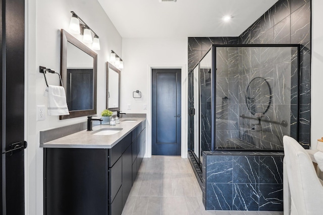 bathroom with a shower stall and double vanity