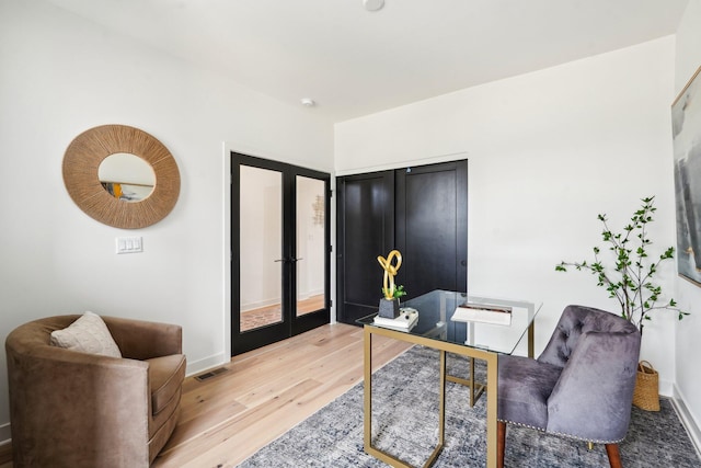office area featuring french doors, light wood-style floors, and baseboards