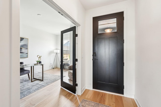 entryway with light wood finished floors and baseboards