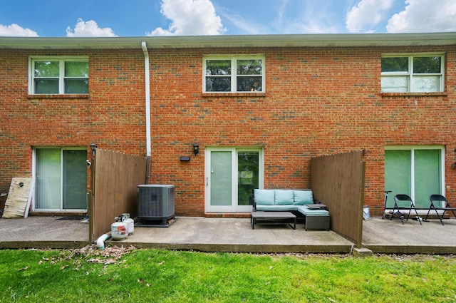 back of house featuring central AC unit, a patio area, and brick siding
