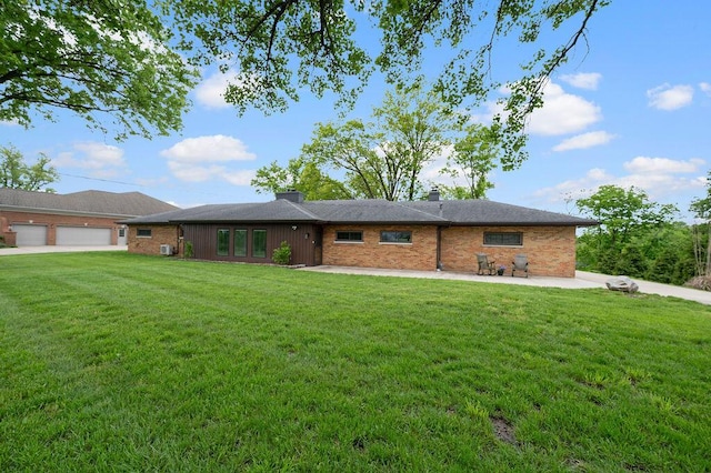 ranch-style home featuring a front lawn, brick siding, and a patio area