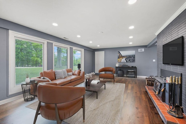 living area with baseboards, wood finished floors, recessed lighting, and a tiled fireplace